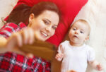 mother and child in bed with red pillow taking selfie