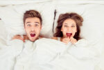 Mum and Dad shocked and excited in bed under all white beddings