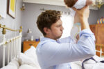 things new babies do, dad holding baby with smelly nappy