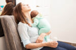 new mum tired with newborn on chest