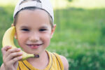 child talking on banana phone to illustrate mobile phone plans for kids