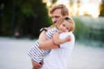 father cuddling daughter