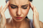 stressed woman holding temples