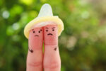 Fingers wearing condom
