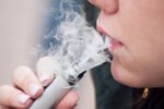 woman smoking liquid nicotine e-cigarette, vaping