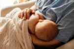 Woman breastfeeding new baby - benefits of breast milk