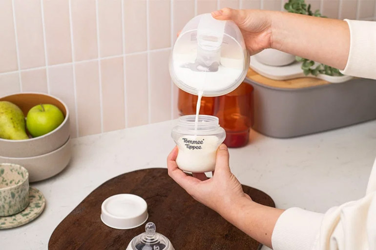 Pouring milk from Tommee Tippee Wearable Breast Pump