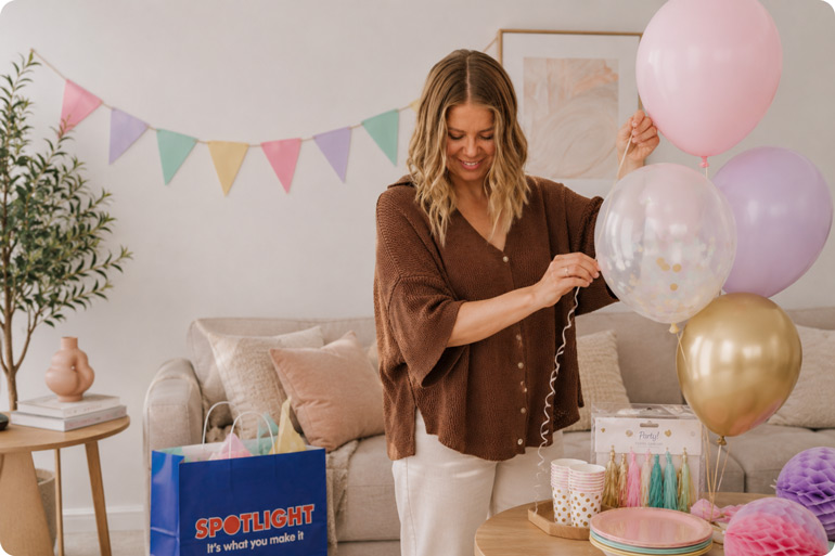 Spotlight birthday party ideas - woman putting together a balloon garland