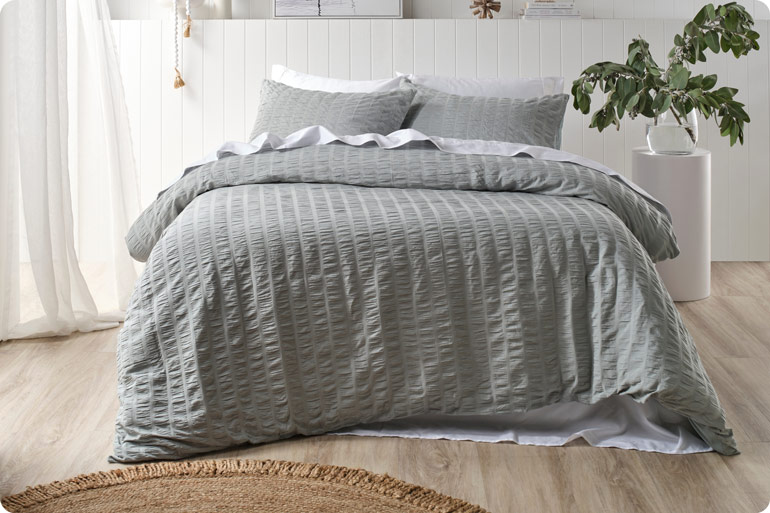 The Sensory Bedtime Tweaks That Help Exhausted Mums Wind Down 5 Made bed in a calm bedroom with soft lighting
