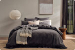 Koo Home Store made bed with a soft textured throw folded across the end