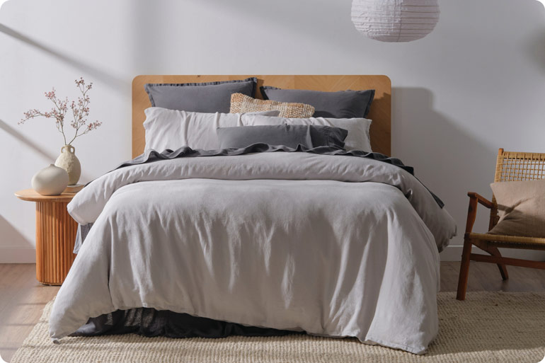 The Sensory Bedtime Tweaks That Help Exhausted Mums Wind Down 4 Bed layered with a light quilt and cotton sheets for temperature control